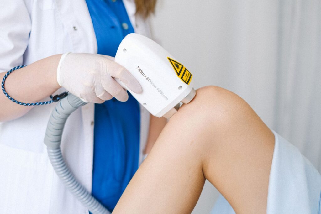 Doctor performing low-level laser therapy on a patient knee