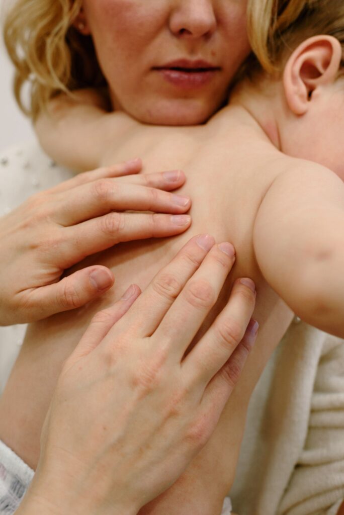 Gentle fingertip pressure applied to a baby's back
